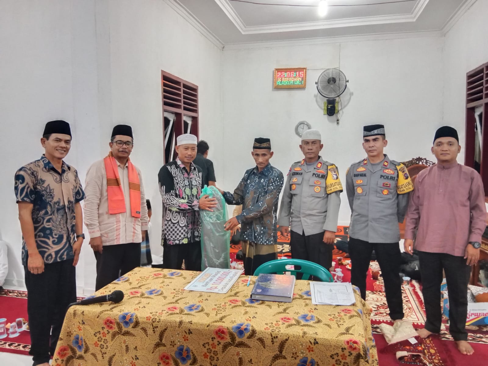 Anggota DPRD Dharmasraya H. Sutan Alif Tuanku Kerajaan, S. H., serahkan bantuan yikar shalat kepada pengurus Mushallah Baiturrahman Padang Laweh